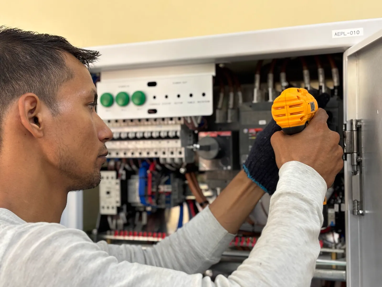 a technician checking an electrical control panel